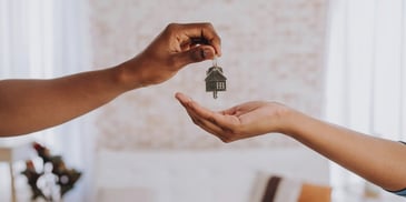 A real estate agent handing a person the keys to their new home
