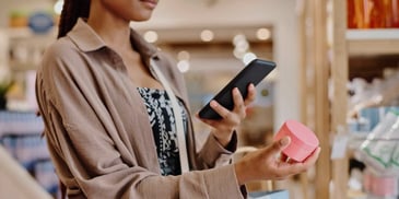 A young shopper taking a photo of a beauty product on her phone