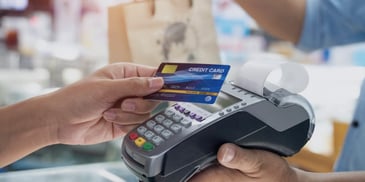 A person using their credit card to make a purchase in a store.