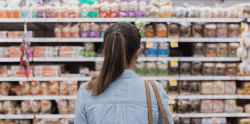 A woman browsing a grocery store aisle