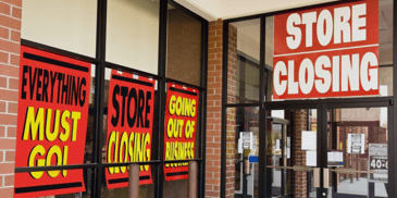 A storefront covered in store closure signs
