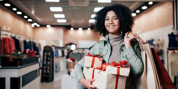 holiday shopper in-store with wrapped presents