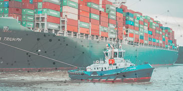 boat in water with large freight ship carrying containers in background