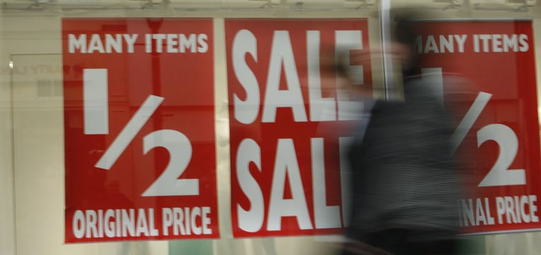 Sale signage on a store front facing a busy street